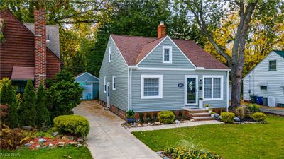 View of front of home featuring an outdoor structure, a garage, and a front lawn | Image 1