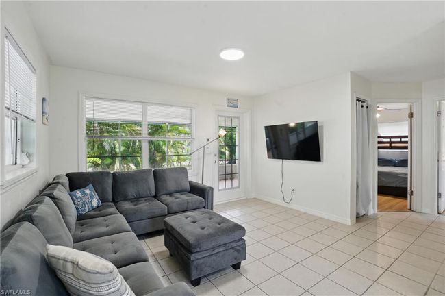 Living room with light tile patterned floors and healthy amount of natural light | Image 18