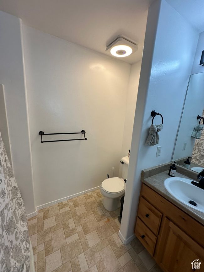 Bathroom with toilet, stone finish floor, vanity, and baseboards | Image 14