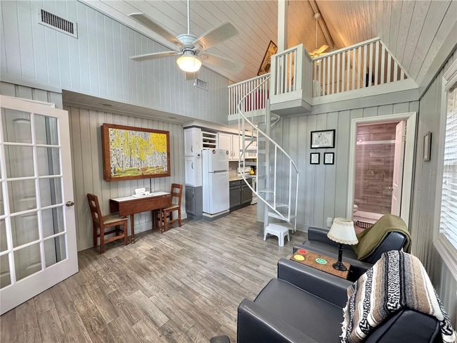 Living room with spiral stairs to loft bedroom | Image 5