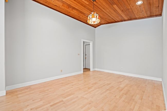 Empty room featuring wood ceiling, light wood finished floors, lofted ceiling, and recessed lighting | Image 13