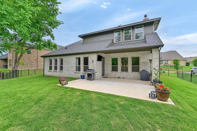 Rear view of house with a yard, roof with shingles, a patio, and a fenced backyard | Image 33