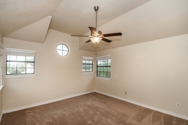 Unfurnished room with carpet floors, a ceiling fan, lofted ceiling, and a textured ceiling | Image 11
