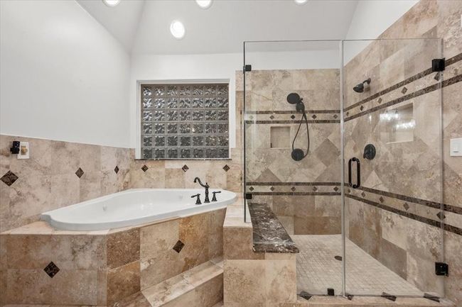 The luxurious ensuite bath boasts a soaking tub, custom tilework, and serene tones for the ultimate spa-like experience. | Image 23