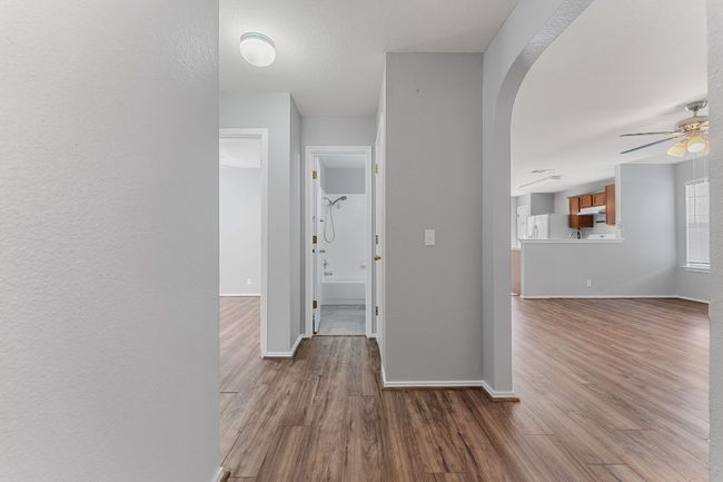 Hallway with wood finished floors and arched walkways | Image 4