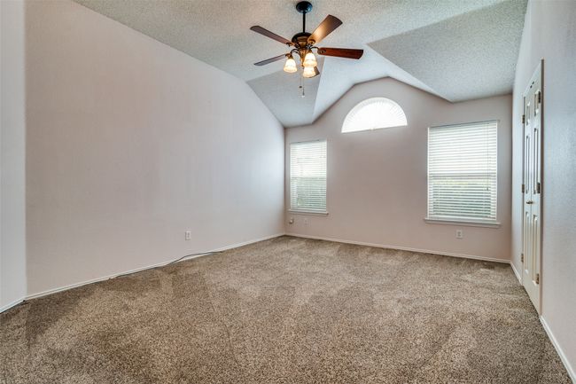 Carpeted empty room with lofted ceiling, a textured ceiling, and a ceiling fan | Image 20