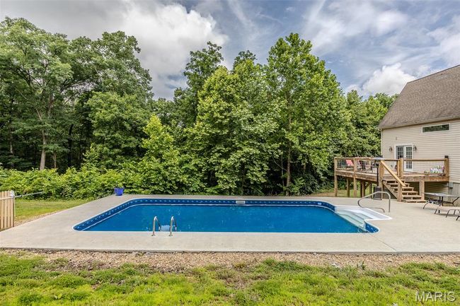 Outdoor pool with a deck and a patio area | Image 58