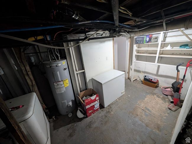 Unfinished basement featuring washer / clothes dryer, fridge, and water heater | Image 10