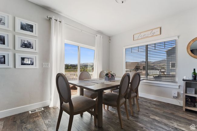 Dining space with visible vents, dark wood-style flooring, and baseboards | Image 8