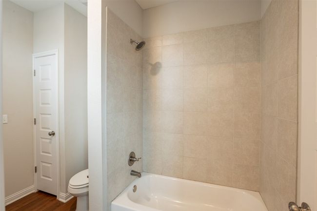 Full bathroom with shower / bath combination, wood finished floors, and toilet | Image 16
