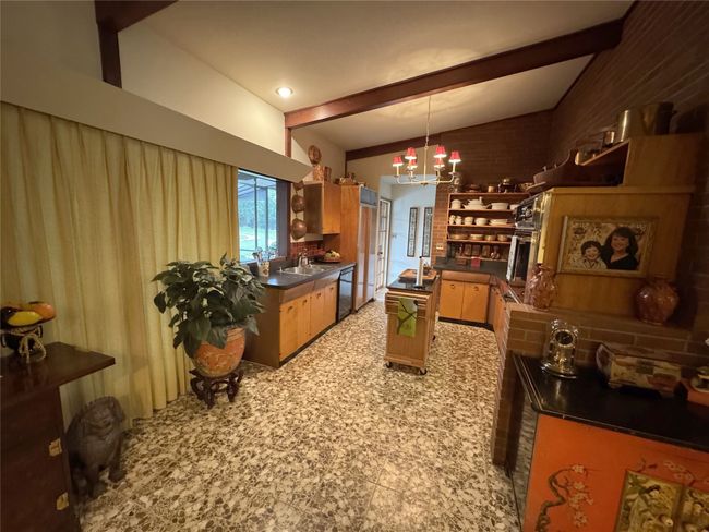Kitchen featuring dishwashing machine, dark countertops, a sink, and open shelves | Image 26