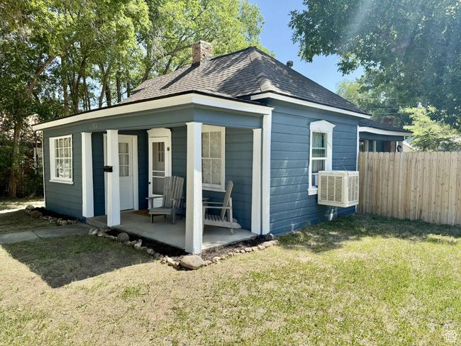 View of front facade with a chimney, a porch, roof with shingles, and cooling unit | Image 30