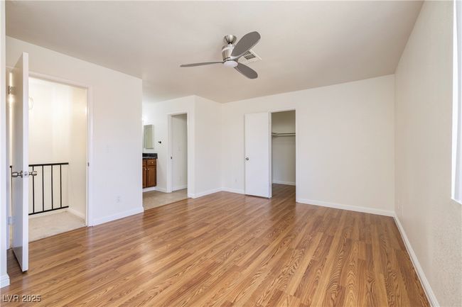 Unfurnished bedroom featuring light wood-style flooring, a ceiling fan, and ensuite bath | Image 16