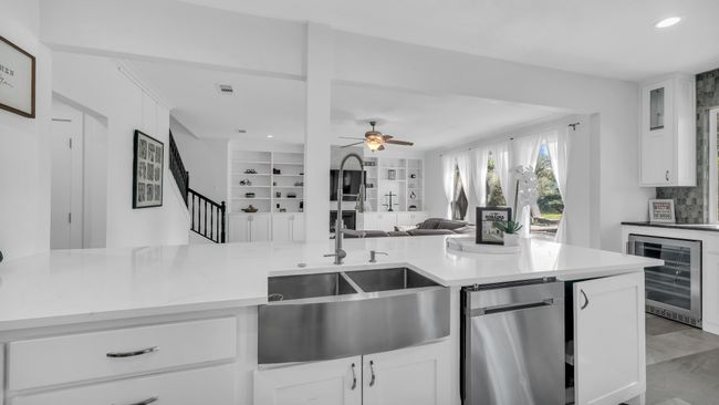 Kitchen with wine cooler, recessed lighting, a ceiling fan, open floor plan, and white cabinets | Image 13