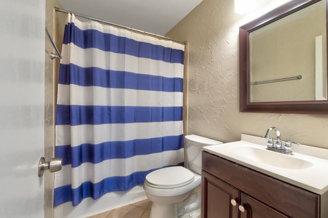 Secondary full bathroom at the end of the hallway with built-in shelving for added storage. | Image 21