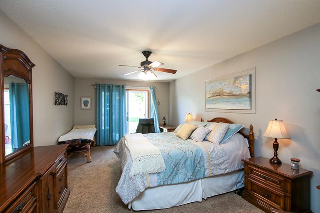 The primary bedroom features a patio door that leads out to the backyard. | Image 6