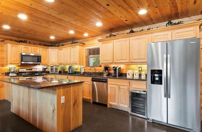 Kitchen with stainless steel appliances, light brown cabinetry, a sink, recessed lighting, and wooden ceiling | Image 11