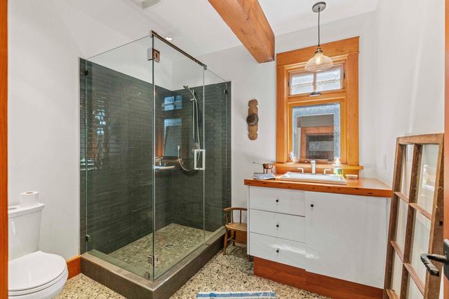 Bathroom with toilet, vanity, a stall shower, speckled floor, and baseboards | Image 25