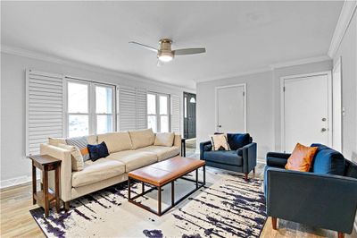 Family room featuring ornamental molding, ceiling fan, and light LV / wood-style floors | Image 3