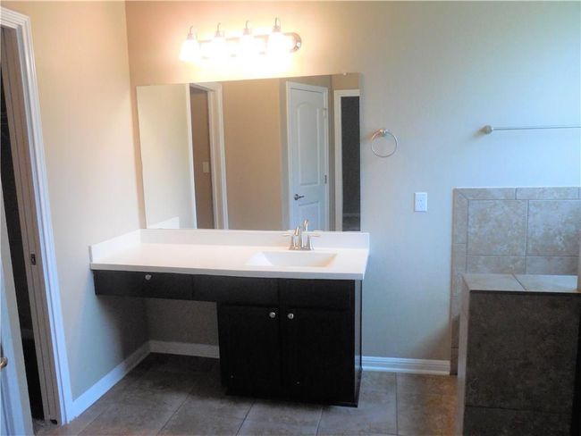 Bathroom with vanity, baseboards, and tile patterned floors | Image 10
