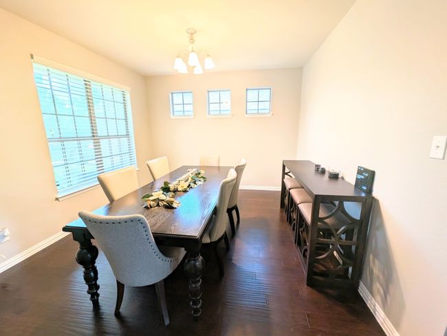 Dining room featuring a chandelier and dark wood-style floors | Image 16