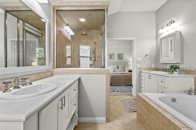 The primary bathroom offers two vanities, a steam shower, and jetted tub | Image 26