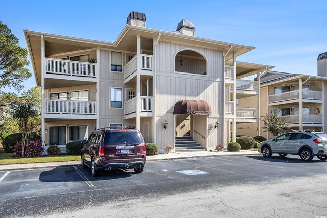 View of apartment building / complex featuring uncovered parking | Image 26