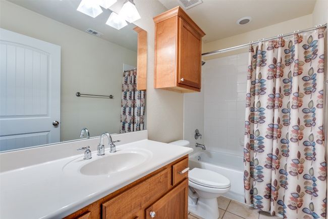 Full bathroom featuring a skylight, vanity, tile patterned flooring, and shower / bath combo | Image 25