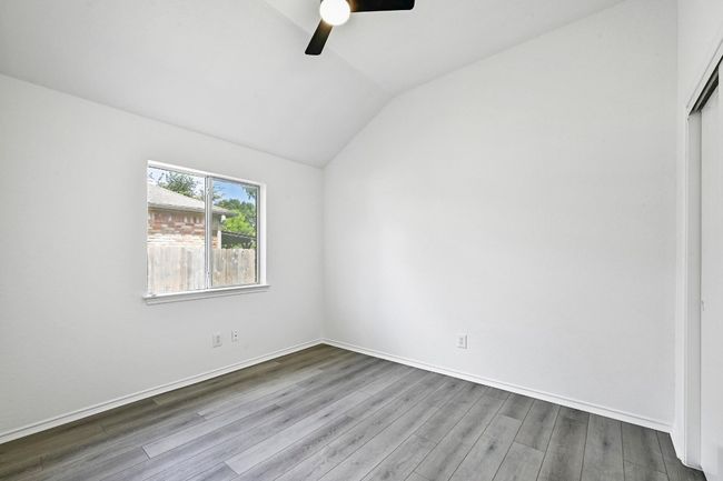 Unfurnished bedroom featuring vaulted ceiling, wood finished floors, a closet, and a ceiling fan | Image 24