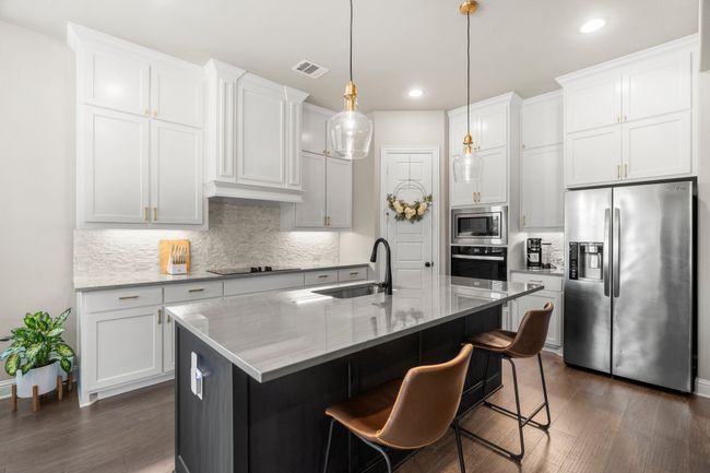 Kitchen with appliances with stainless steel finishes, tasteful backsplash, white cabinets, and recessed lighting | Image 10