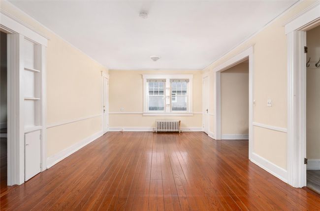 Unfurnished room featuring radiator, baseboards, and hardwood / wood-style floors | Image 8