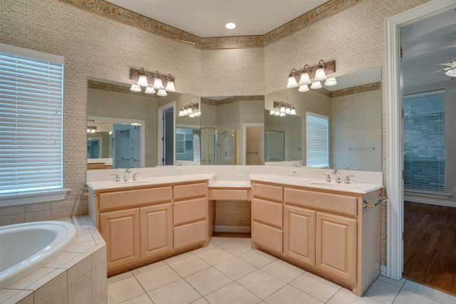 Full bathroom featuring tile patterned flooring, vanity, a bath, and a shower stall | Image 20