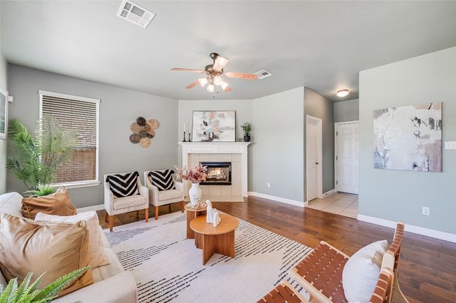 Living area with hardwood / wood-style floors, a tiled fireplace, and a ceiling fan | Image 12