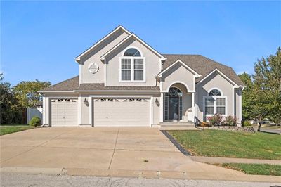 View of property with a front lawn and a garage | Image 1