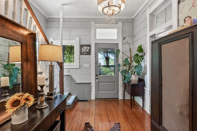 Entryway featuring hardwood / wood-style floors, a chandelier, and ornamental molding | Image 6
