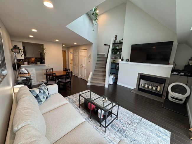 Living room featuring stairs, recessed lighting, wood finished floors, and a tile fireplace | Image 8