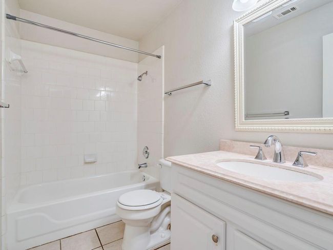 Full bathroom featuring vanity, washtub / shower combination, and tile patterned floors | Image 23