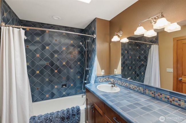 Third bathroom with slate flooring and glaze ceramic artisan tile with extra-long garden tub and double vanity. | Image 26
