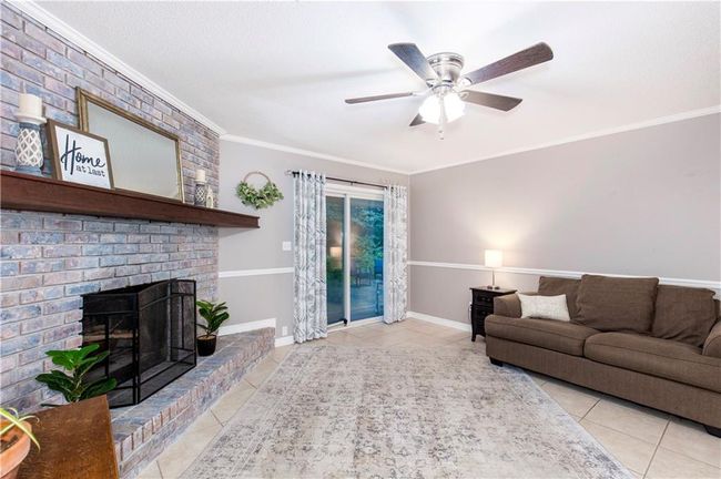 Living area featuring tile floors, ornamental molding, ceiling fan, and a fireplace | Image 5