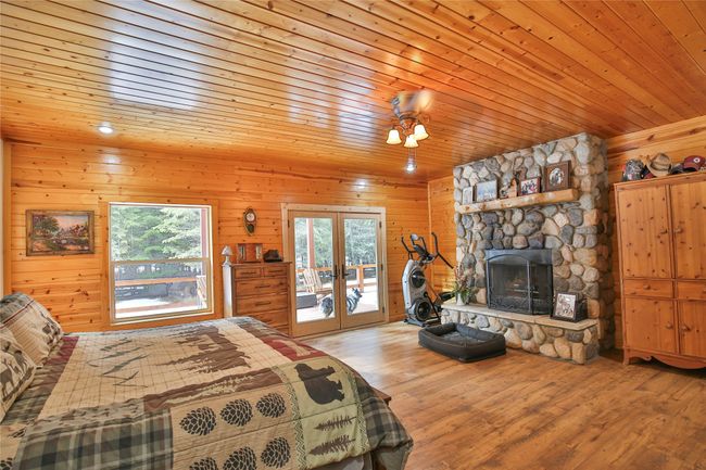 Bedroom with wood ceiling, access to outside, multiple windows, and wood finished floors | Image 14
