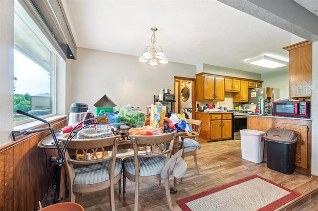 Dining space with stacked washing machine and dryer, a chandelier, and light wood-style flooring | Image 18