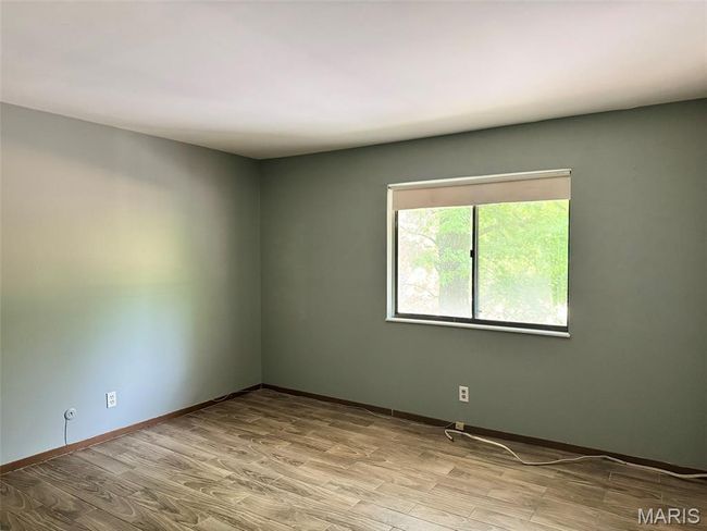 Spare room featuring wood finished floors and baseboards | Image 5