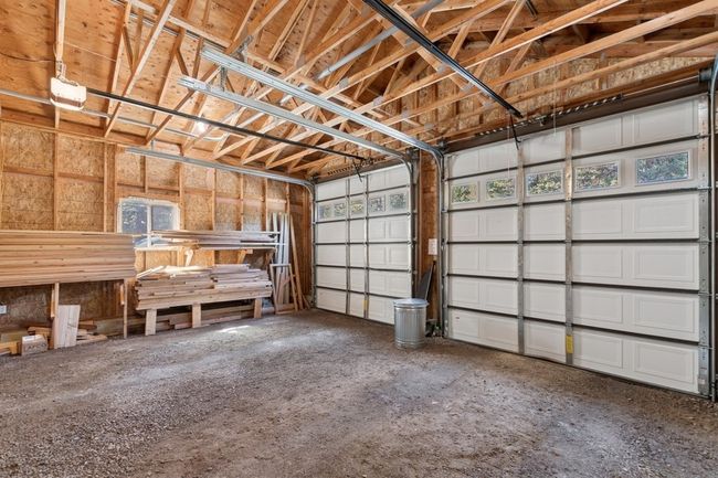 View of detached garage stalls with tall doors and electricity | Image 25