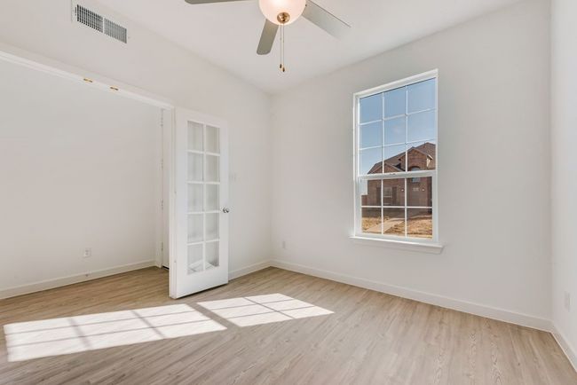Spare room featuring wood finished floors, a ceiling fan, and french doors | Image 16