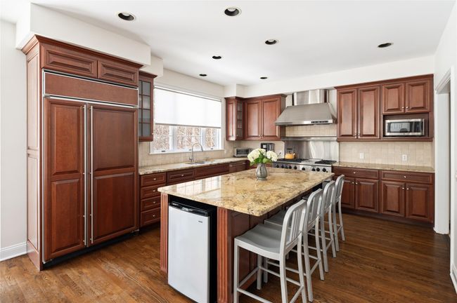 Kitchen with high end stainless steel appliances, sink, a center island, and glass insert cabinets | Image 11