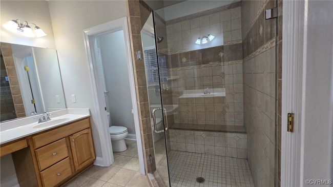 First Floor Full bath featuring a stall shower, tile patterned flooring, toilet, and vanity | Image 30