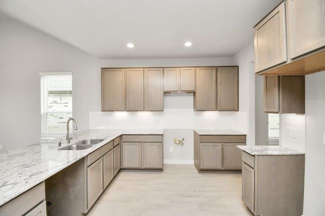 This kitchen is by far any chef’s dream! This spacious kitchen features high ceilings, dark stained wood cabinets, granite countertop, SS appliances (To be Installed), modern tile backsplash, recessed lighting, extended counter space and all overlooking your huge family room. | Image 13