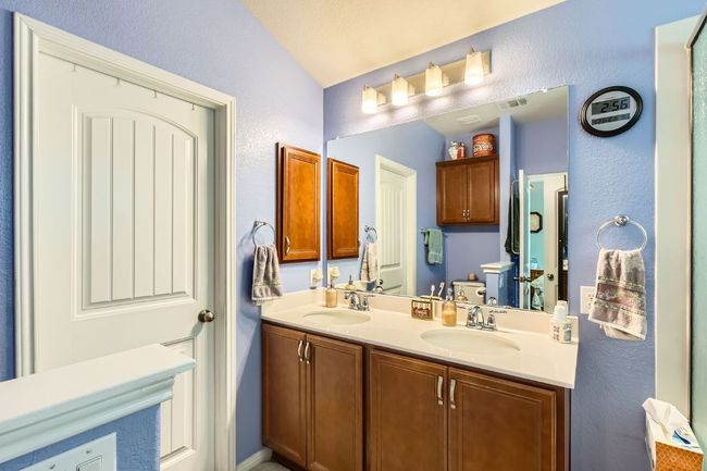Bathroom featuring double vanity, a textured wall, visible vents, and a sink | Image 16