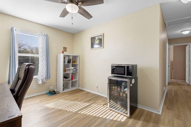 Home office featuring baseboards, ceiling fan, wood finished floors, and beverage cooler | Image 18