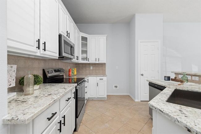 The kitchen offers ample cabinet and counter space making it functional and stylish. | Image 12